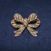 Brooch 'Accent Bow' 55x45mm with crystals, green and yellow, gold-tone metal