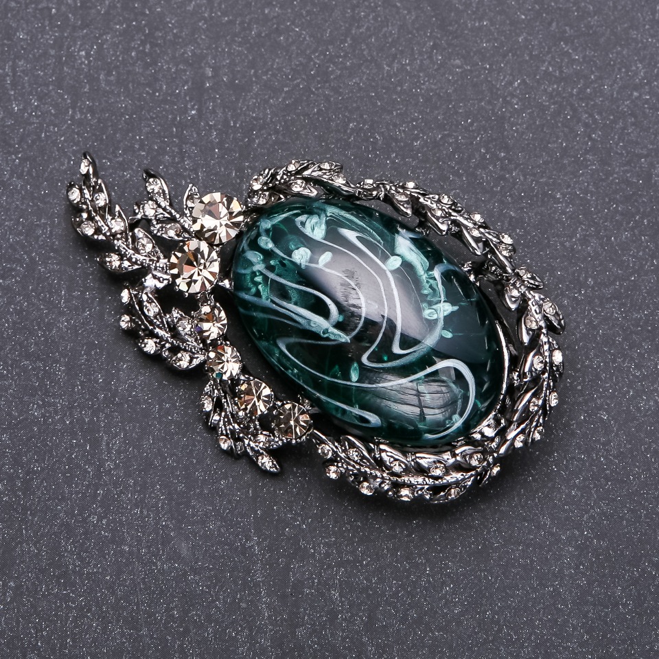 Brooch with gray crystals and emerald cabochon 64×38 mm gray metal