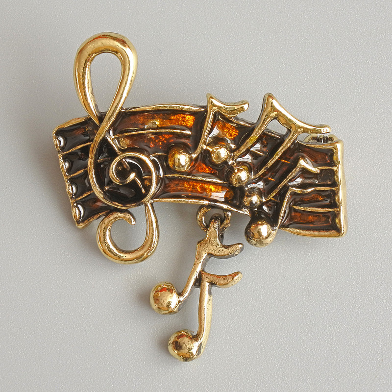 Brooch 'Notes' with brown enamel and gold-tone metal, 33x26 mm
